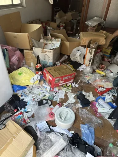 滋賀県のゴミ屋敷片付け前。床を覆う段ボールや生活用品